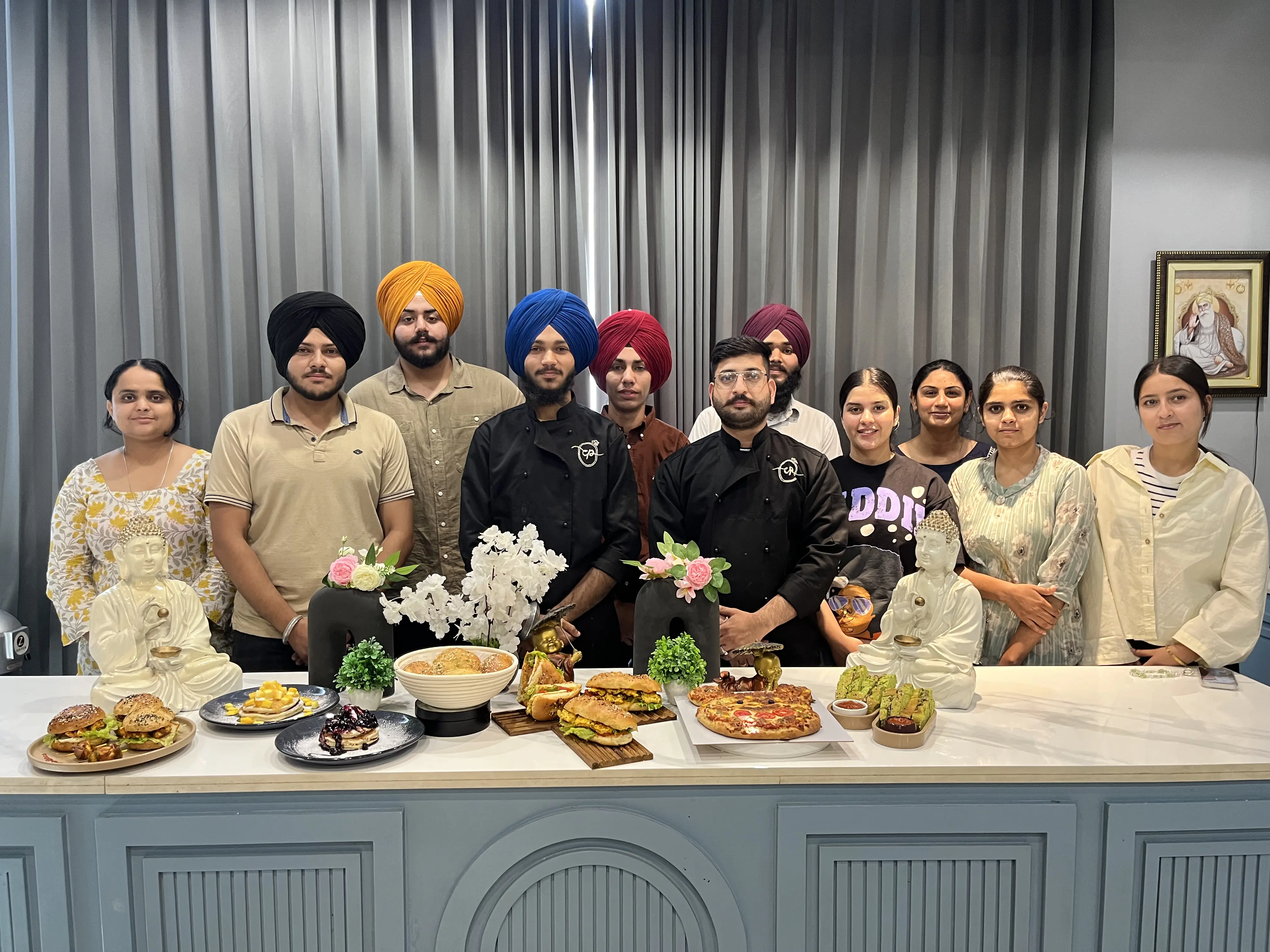 A culinary cohort with their plated dishes on display in the studio