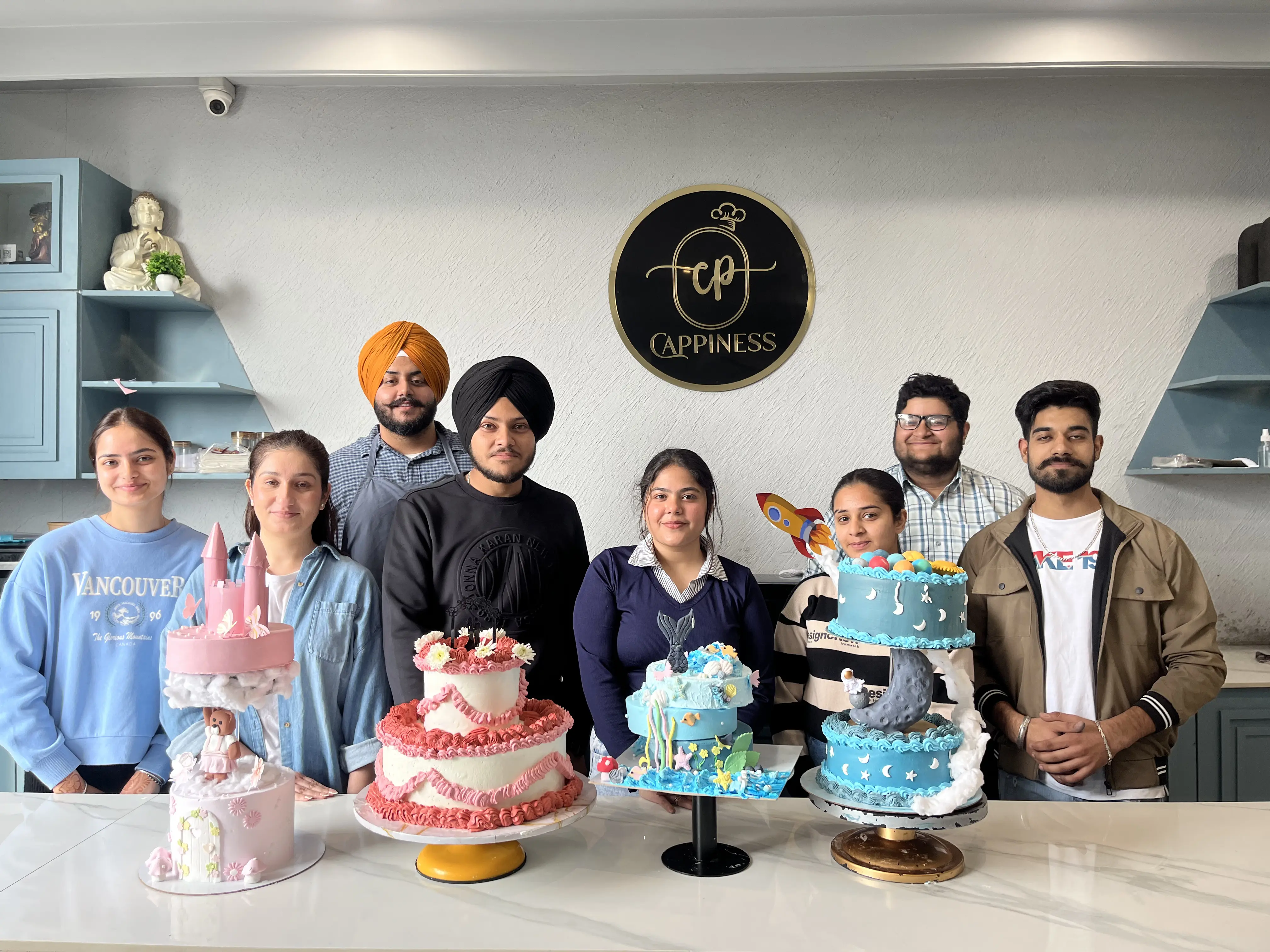 A Cappiness student cohort presenting their finished celebration cakes
